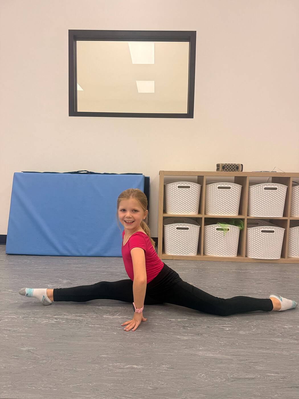 Smiling young dancer in a split at Tempo Dance Studio